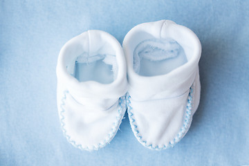 Image showing close up of baby bootees for newborn boy on blue