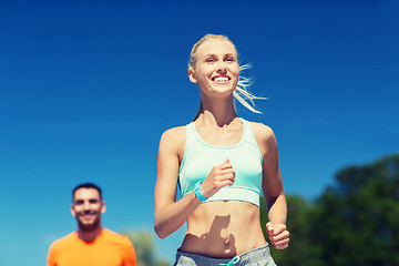 Image showing smiling couple running outdoors