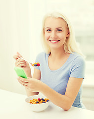 Image showing smiling woman with smartphone eating  breakfast 