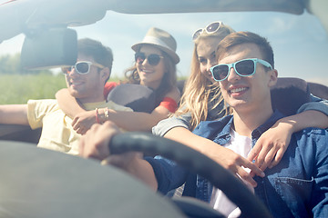 Image showing happy friends driving in cabriolet car outdoors