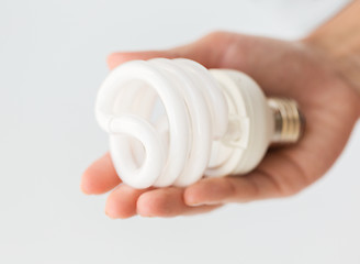 Image showing close up of hand holding energy saving lightbulb