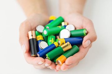 Image showing close up of hands holding alkaline batteries heap