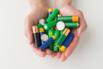 Image showing close up of hands holding alkaline batteries heap