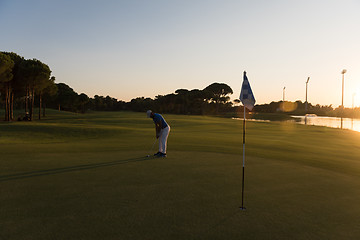 Image showing golfer hitting ball to hole