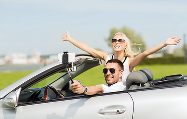 Image showing happy couple in car taking selfie with smartphone