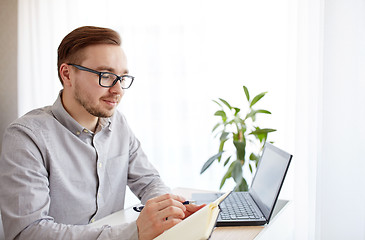 Image showing creative man or businessman writing to notebook