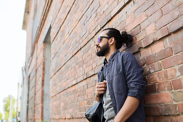 Image showing man with backpack standing at city street wall