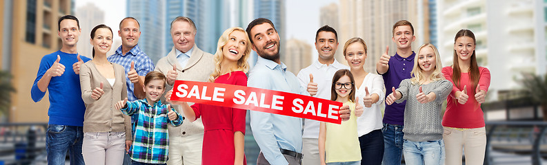 Image showing happy people with sale sign showing thumbs up