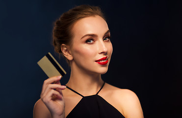 Image showing beautiful woman with credit card over black