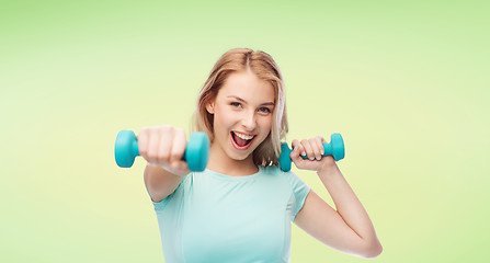 Image showing smiling beautiful young sporty woman with dumbbell