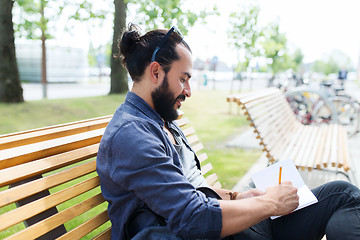 Image showing man with notebook or diary writing on city street
