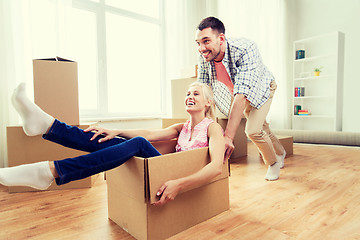 Image showing couple with cardboard boxes having fun at new home