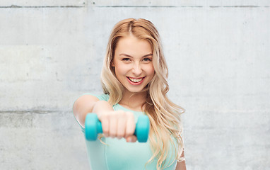 Image showing smiling beautiful young sporty woman with dumbbell