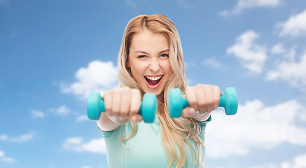 Image showing smiling beautiful young sporty woman with dumbbell