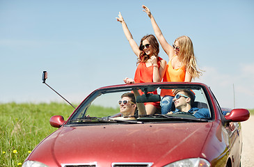 Image showing friends driving in cabriolet car and taking selfie