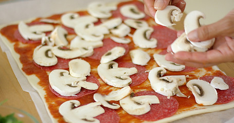 Image showing Woman making a delicious pepperoni pizza