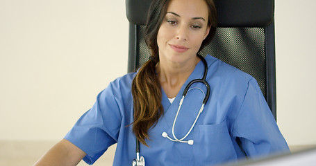 Image showing Young female physician places one hand on her face