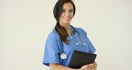 Image showing Woman in scrubs holds black portfolio and smiles