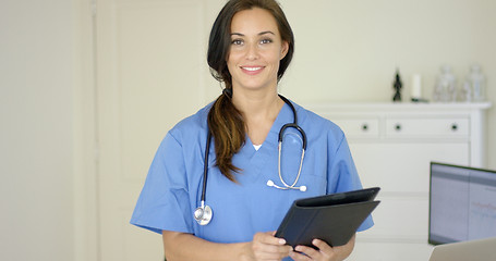 Image showing Smiling young female physician smiles at camera