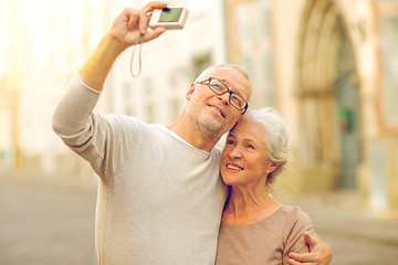 Image showing senior couple photographing on city street