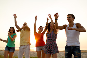 Image showing smiling friends dancing on summer beach