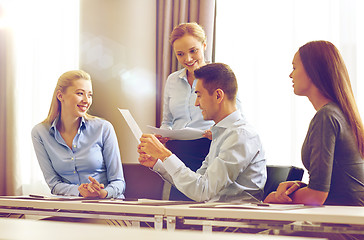 Image showing smiling business people with papers in office