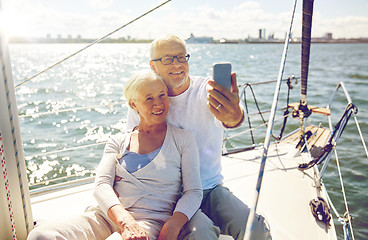 Image showing seniors with smartphone taking selfie on yacht