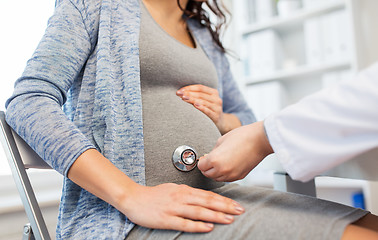 Image showing doctor with stethoscope and pregnant woman belly