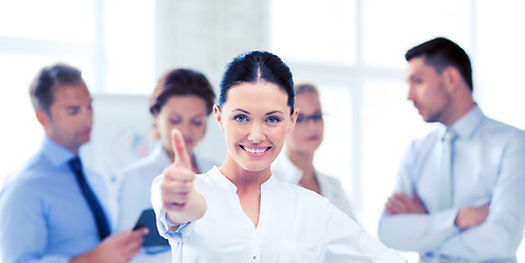 Image showing businesswoman in office showing thumbs up