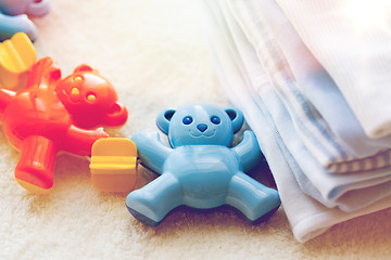 Image showing close up of baby rattle and clothes for newborn