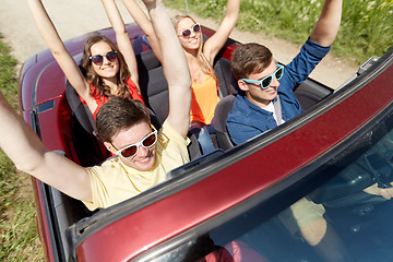 Image showing happy friends driving in cabriolet car at country