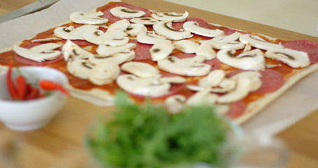 Image showing Woman making a delicious pepperoni pizza