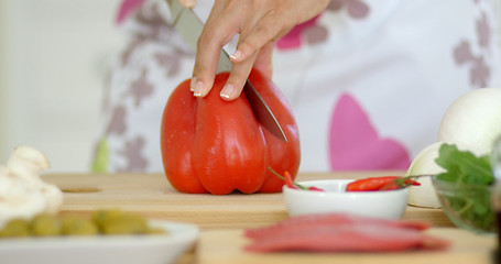 Image showing Housewife chopping a fresh red bell pepper