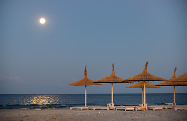 Image showing Parasol on a beach and moon