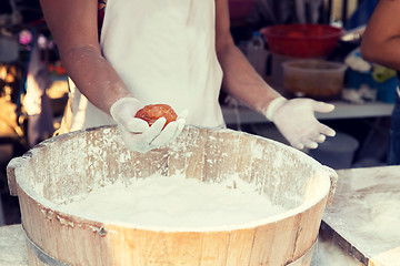 Image showing close up of cook hands with meatball and flour