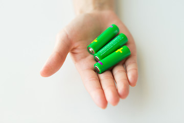 Image showing close up of hand holding green alkaline batteries