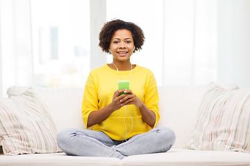 Image showing happy african woman with smartphone and earphones