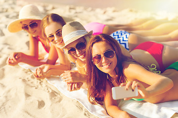 Image showing group of smiling women with smartphone on beach