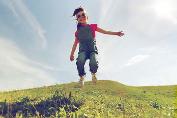 Image showing happy little girl jumping high outdoors