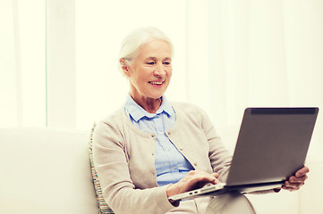 Image showing happy senior woman with laptop at home