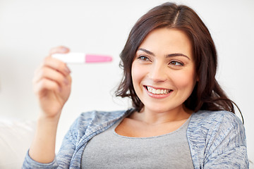 Image showing happy woman looking at home pregnancy test