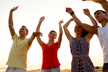 Image showing smiling friends dancing on summer beach