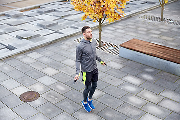 Image showing man exercising with jump-rope outdoors