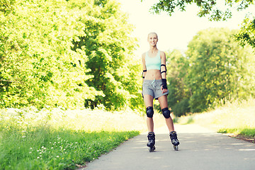 Image showing happy young woman in rollerblades riding outdoors