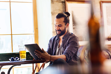 Image showing man with tablet pc drinking beer at bar or pub