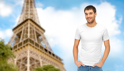 Image showing happy man in blank white t-shirt over eiffel tower