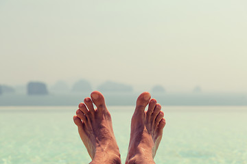 Image showing closeup of male feet over sea and sky on beach