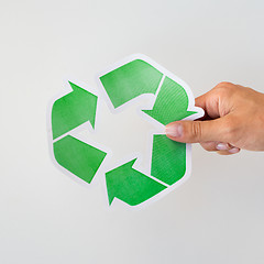 Image showing close up of hand holding green recycle symbol