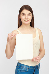 Image showing Young smiling woman show blank card