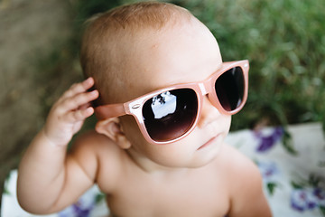 Image showing Baby in big sunglasses on a river